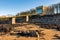 A coastal boat house and boat launch ramp slipway on a rocky beach in winter