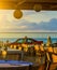 Coastal cafes and taverns with traditional interior, Greece. Tables and chairs, hanging decorative lamps. Car on background.