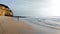 Coastal cliffs and foamy surf on the beach of the Atlantic Ocean at Armacao de Pera, Algarve, Portugal