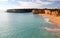 Coastal cliffs and sandy beach on sunny morning in Algarve, Armacao de Pera, Portugal