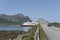 Coastal cruiser sails under high bridge at Risoyhamn, Norway