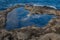 Coastal erosion ,hole in rocky beach in the shape of a heart ,saint florent ,corsica concept of romatic holidays