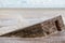 Coastal erosion and rising sea level reclaiming a WW2 beach defence building.