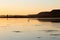 A coastal lagoon with a heron in silhouette seen during a beautiful late summer golden hour afternoon