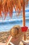 Coastal landscape - straw hat on a deck chair on the background of the sandy seashore