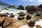 Coastal stones lay on white sands of Beau Vallon beach, Seychelles