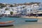 Coastal view of the white village of Mykonos, Greece, with cruise ship tourists shopping along the beach promenade.