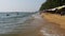 Coastline of the beach. People bathe in the sea, water rides, wave beat on the sandy shore. Thailand. Pattaya.