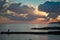 Coastline with beaches, breakwaters and people silhouette on the background of a bright sunset