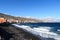 Coastline, black sand pebble beach and town Candelaria panorama with Atlantic Ocean on Canary Island Tenerife, Spain