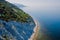 Coastline with blue sea and highest cliff with pine trees. Summer on sea. Aerial view