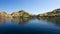 Coastline of mountains with green vegetation reflected in blue ocean water at Labuan Bajo in Flores.