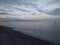 Coastline with pebble stones, sea, horizon line and sunset light on background, Sicily, Italy