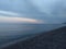 Coastline with pebble stones, sea, horizon line and sunset light on background, Sicily, Italy