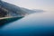 Coastline with quiet sea and highest cliff with trees. Summer day on sea. Aerial view