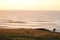 Coastline with rocks, a blue sky and incoming waves during sunset