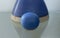 Cobalt blue ceramic ball in front of a blue pot.