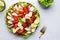 Cobb salad with chicken fillet, tomatoes, eggs, bacon, avocado and lettuce, gray table background, top view. American cuisine dish