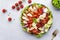 Cobb salad with chicken fillet, tomatoes, eggs, bacon, avocado and lettuce, gray table background, top view. American cuisine dish