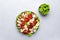 Cobb salad with chicken fillet, tomatoes, eggs, bacon, avocado and lettuce, gray table background, top view. American cuisine dish