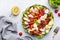 Cobb salad with chicken fillet, tomatoes, eggs, bacon, avocado and lettuce, gray table background, top view. American cuisine dish