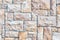 Cobble brown stone siding tile wall abstract background. House exterior with blocks tiled with cement . Crafted