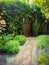 Cobble pathway to the secret gardens entrance of overhanging vines and a old rustic door