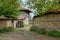 Cobbled road, old traditional houses and walnut tree branches in Zheravna, Bulgaria