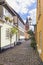 Cobbled street at the old town of Aalborg, Denmark, with bell tower of  Vor Frue Kirke in background