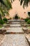 Cobbled walkway leading to a garden fountain