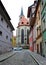 Cobblestone street in the medieval part of the town, Church of the Franciscan Monastery in the background, Cheb, Czechia