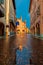 Cobblestone street and San Lorenzo cathedral in Alba, Italy.