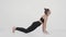 Cobra position. Side view shot of flexible woman performing back stretching exercise, practicing over white background