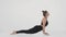 Cobra position. Side view shot of flexible woman performing back stretching exercise, practicing over white background