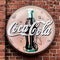 Coca-Cola advertising sign, historical round faded advertising sign on an old brick wall, illustrative editorial