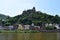 Cochem, Germany - 06 17 2021: Chapel, city walls tower and colorful houses below Reichsburg