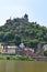 Cochem, Germany - 06 17 2021: city walls tower and colorful houses below Reichsburg