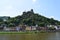 Cochem, Germany - 06 17 2021: Reichsburg above Cochem, colorful waterfront buildings, Pegleturm, City walls tower, chapel