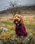 Cockapoo in coat on a rock