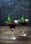 Cocktail Black Night Dancer with balsam and cola decorated by segments of a lemon and green cherry