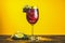 Cocktail with blackcurrant on yellow background
