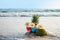 Cocktail glasses with coconut and pineapple on clean sand beach