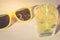 cocktail with ice and yellow sunglasses/cocktail with ice and yellow sunglasses on sunlight