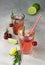 Cocktail or lemonade with cherries, lime and rosemary on a grey concrete table. Summer refreshment drink