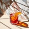 Cocktail with orange and ice on a marble background with shadows