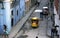 Coco Taxi moves down small street filled with people in Havana