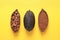 Cocoa beans, powder and pods on yellow background, flat