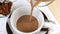 Cocoa drink is poured into cup, spoon on saucer. Natural delicious hot chocolate. Alternative healthy caffeine for breakfast.