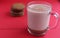 Cocoa hot chocolate in a glass mug on a red background with room for text copyspace and liver on hellish plan