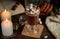 Cocoa or hot chocolate with marshmallows on a wooden table, with books, cookies, a blanket and burning candles